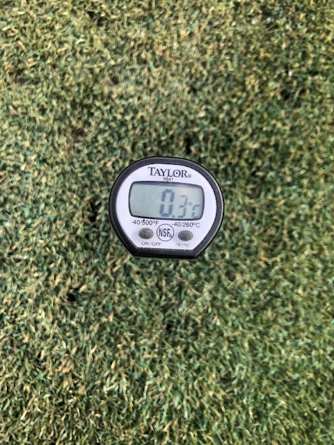 A close up view of a thermometer reading the greens depth temperature. It reads 0.3 Celsius.