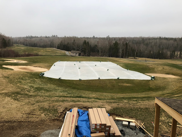 A tarp installed on the 18 green.